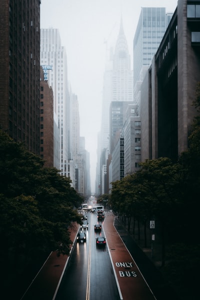 白天，人们在高楼附近的人行道上行走